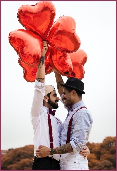 Couple in love holding red heart shaped balloons